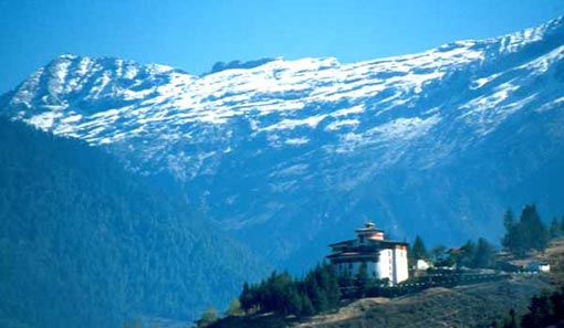 Adventure Tour to  Bhutan - An old Monastery beneath the snow piled mountain.